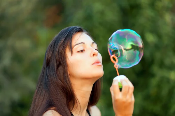 Hezká žena nafukuje mýdlové bubliny — Stock fotografie