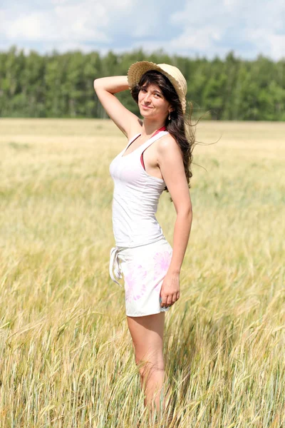 Güneşli bir günde buğday alan üzerinde duran güzel kız — Stok fotoğraf