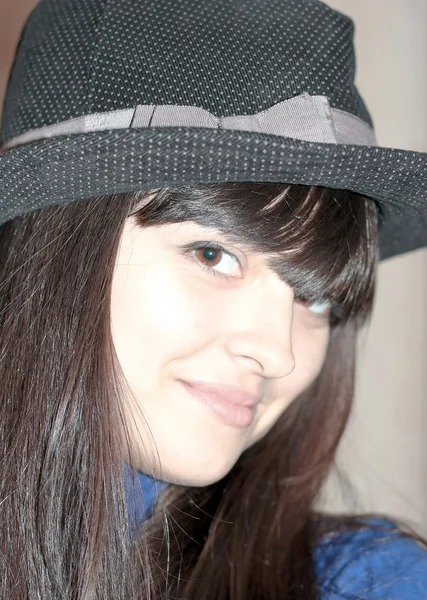 在夜总会中戴着黑色帽子的漂亮黑发女孩的肖像 — 图库照片