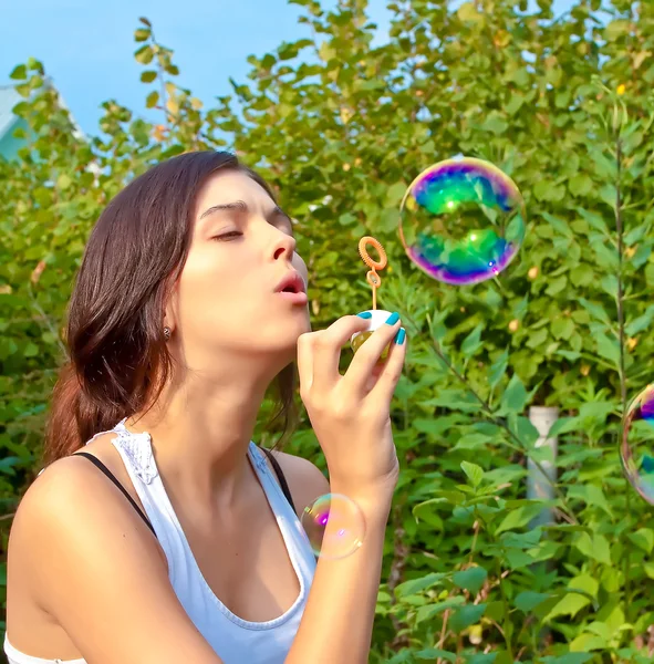 Attractive girl blowing soap bubbles — Stock Photo, Image
