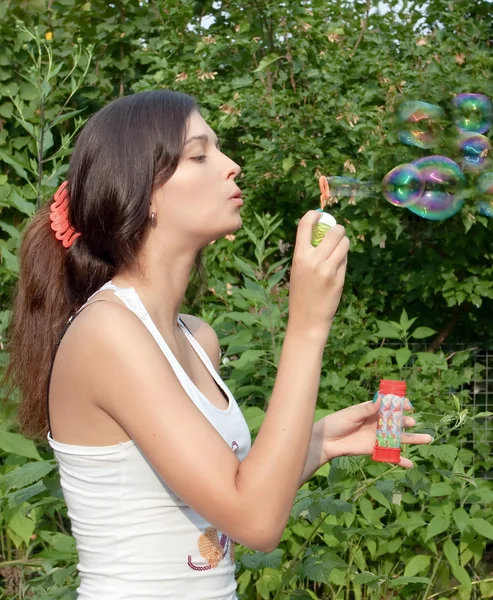 Aantrekkelijk meisje zeepbellen blazen — Stockfoto