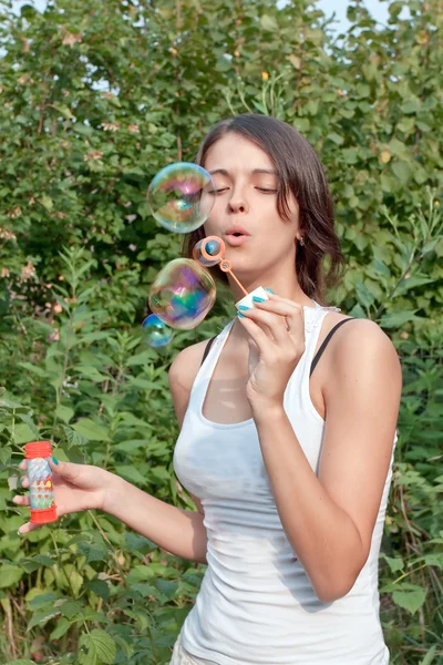 Приваблива дівчина дме мильні бульбашки — стокове фото