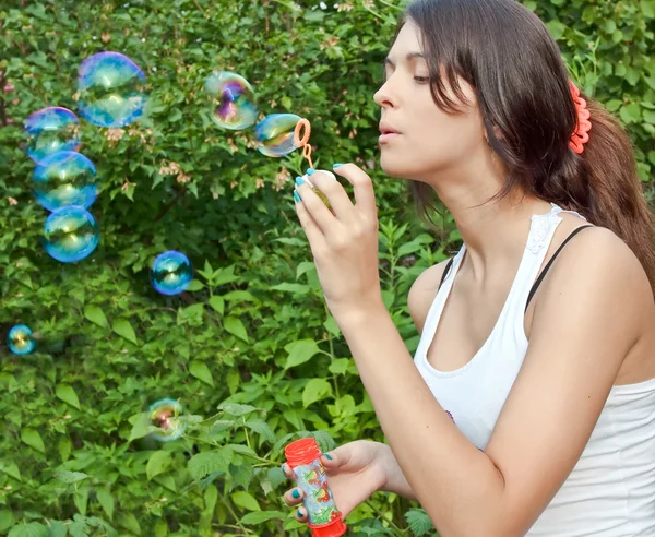 Attractive girl blowing soap bubbles — Stock Photo, Image