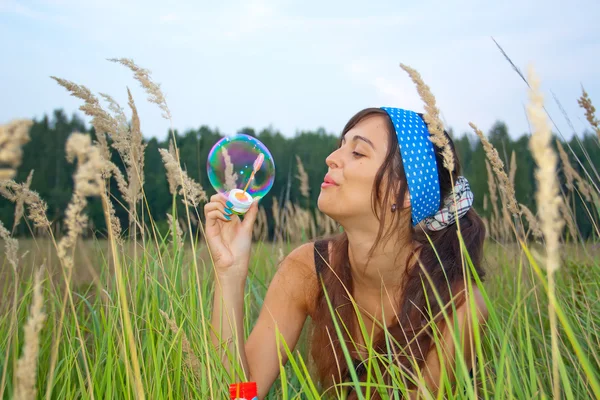 Приваблива молода дівчина з мильними бульбашками — стокове фото