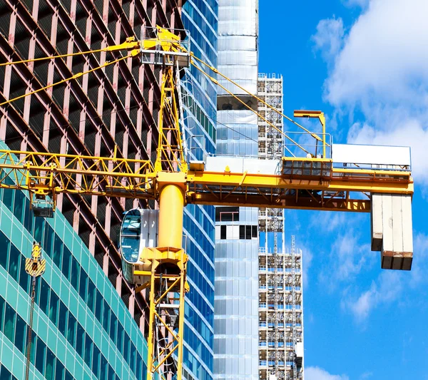 Gelber Kran über dem Bau eines mehrstöckigen Gebäudes — Stockfoto