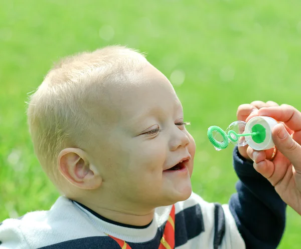 石鹸の泡を膨らませる幸せな子供 — ストック写真