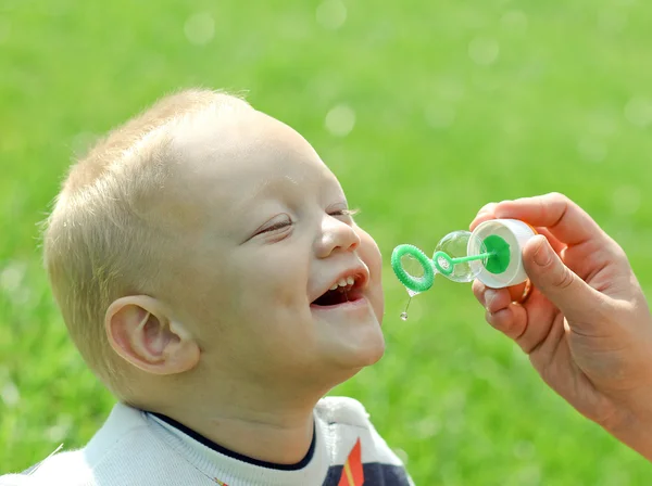 Gelukkig kind opblazen zeepbellen — Stockfoto