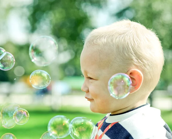 Щаслива дитина надуває мильні бульбашки — стокове фото