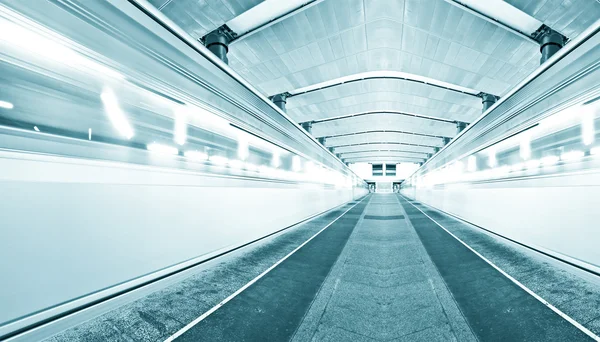 Piattaforma sotterranea blu con treno in movimento — Foto Stock
