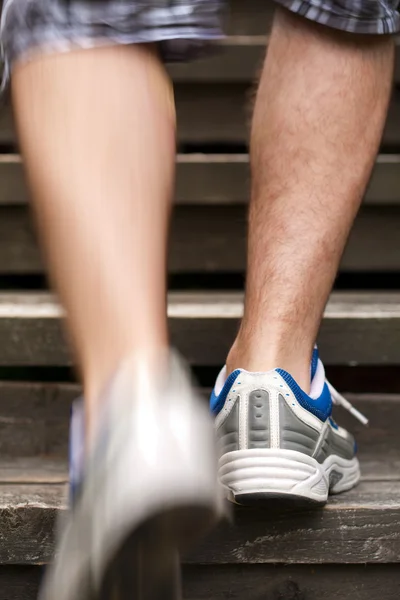 Legs of running man on stairs — Stock Photo, Image