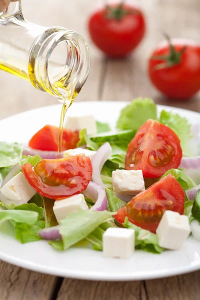 Öl über frischen Salat gießen — Stockfoto