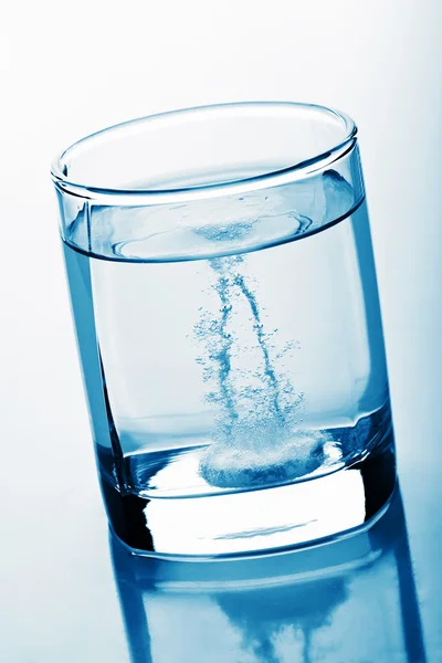 Таблетки в стакане воды — стоковое фото