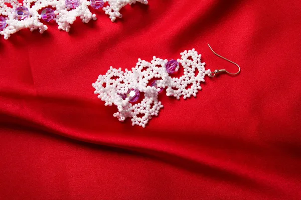 Pink earrings isolated on red — Stock Photo, Image