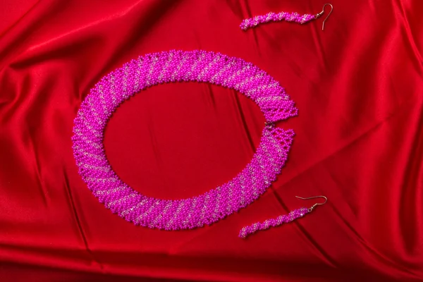 Pendientes rosados aislados en rojo —  Fotos de Stock