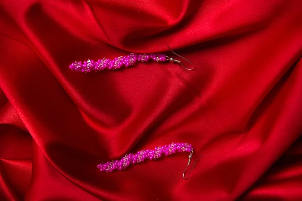 Рожеві сережки ізольовані на червоному — стокове фото