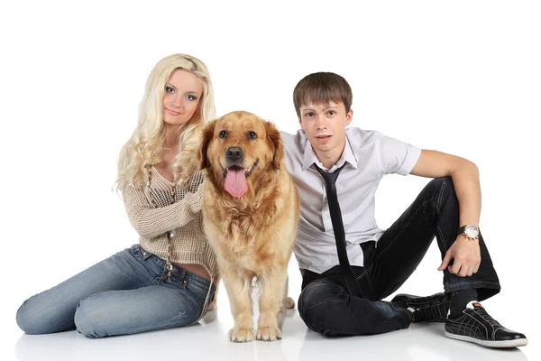 Młode rodziny z psem, siedząc na podłodze, patrząc na kamery — Zdjęcie stockowe