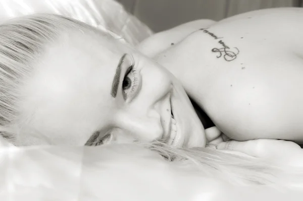 Krásná usměvavá blondýnka v ložnici — Stock fotografie