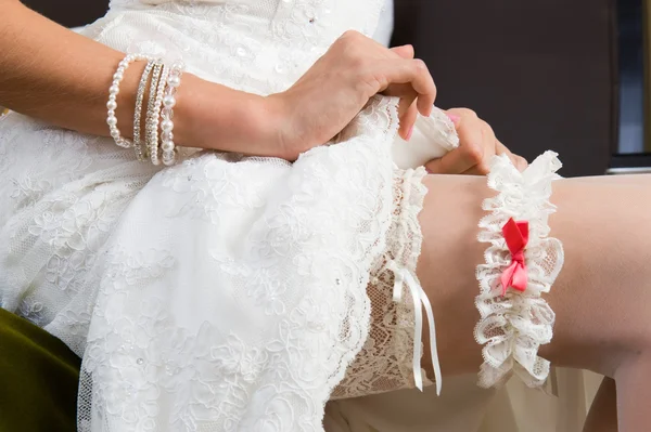 Weißes Strumpfband, angezogen am Bein der Braut. — Stockfoto
