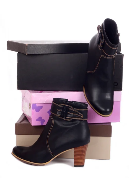 Pair of black winter woman boots and many boxes — Stock Photo, Image