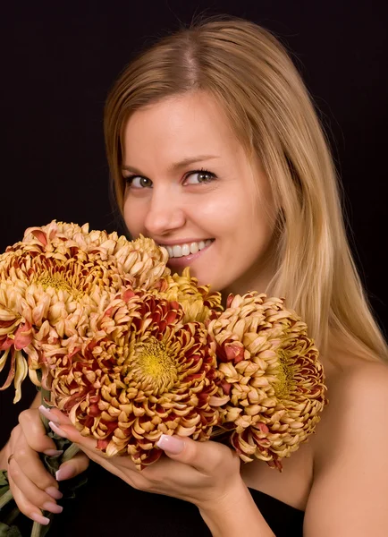 Imagen de una joven con crisantemos amarillos —  Fotos de Stock