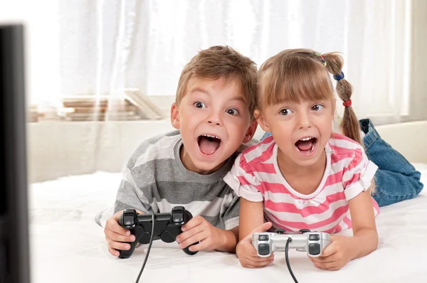 Happy girl and boy playing a video game — Stock Photo, Image