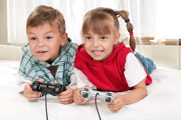Счастливые девочка и мальчик играют в видеоигру — стоковое фото
