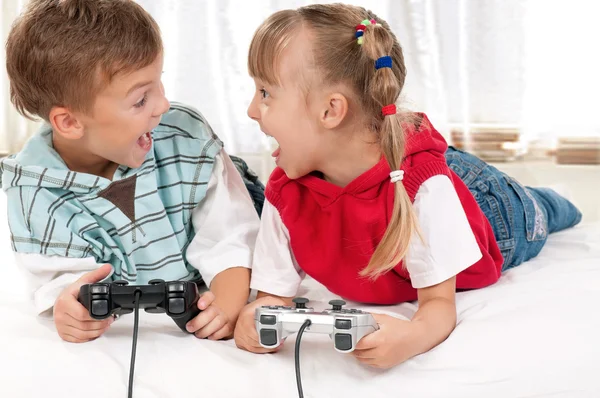 Šťastná dívka a chlapec hraje video hry — Stock fotografie