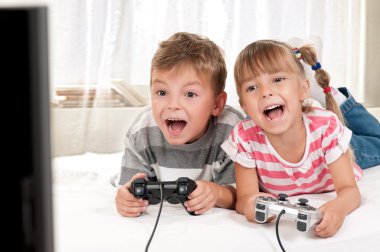 Happy girl and boy playing a video game clipart