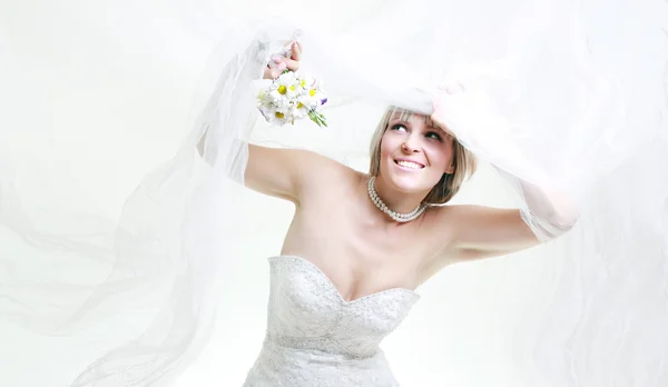 Krásná mladá žena v bílých šatech s kyticí květin — Stock fotografie