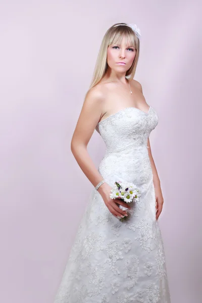Krásná mladá žena v bílých šatech s kyticí květin — Stock fotografie