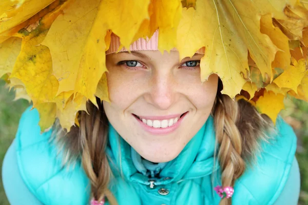 Mujer joven en hojas de otoño — Foto de Stock