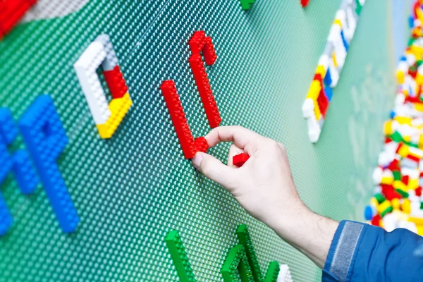Criança brincando com tijolos de brinquedo de plástico — Fotografia de Stock