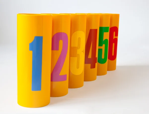 Yellow plastic cans numbered one to six — Stockfoto
