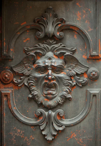 Cara monstruosa esculpida em uma porta — Fotografia de Stock