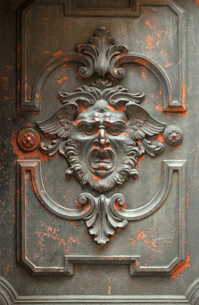 Cara monstruosa esculpida em uma porta — Fotografia de Stock
