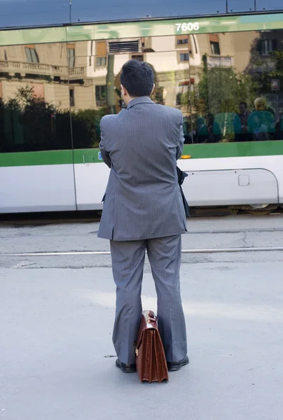 Бизнесмен ждет трамвай — стоковое фото