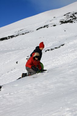 Çocuklar karda oynuyor.