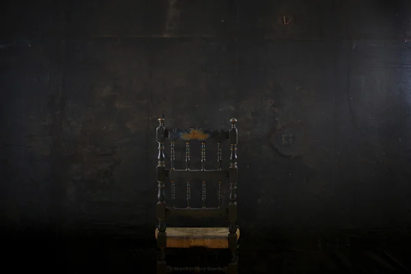 Καρέκλα σε μαύρο τοίχο — Φωτογραφία Αρχείου