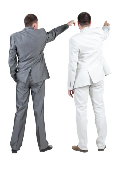 Вид ззаду на двох бізнесменів, які вказують на стіну. вид ззаду . — стокове фото