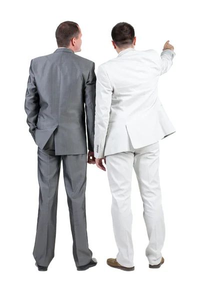 Back view of two businessman pointing at wall. rear view. — Stock Photo, Image