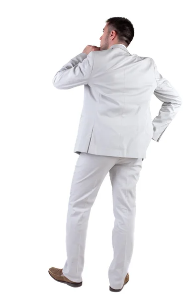 Achteraanzicht van denken jonge zakenman in wit pak.. — Stockfoto