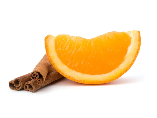 オレンジ色の果物セグメントと白い背中に分離されたシナモンスティック — ストック写真