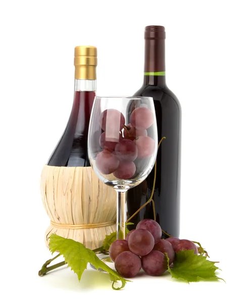 Kieliszek do wina z winogron i dwie butelki wina — Zdjęcie stockowe