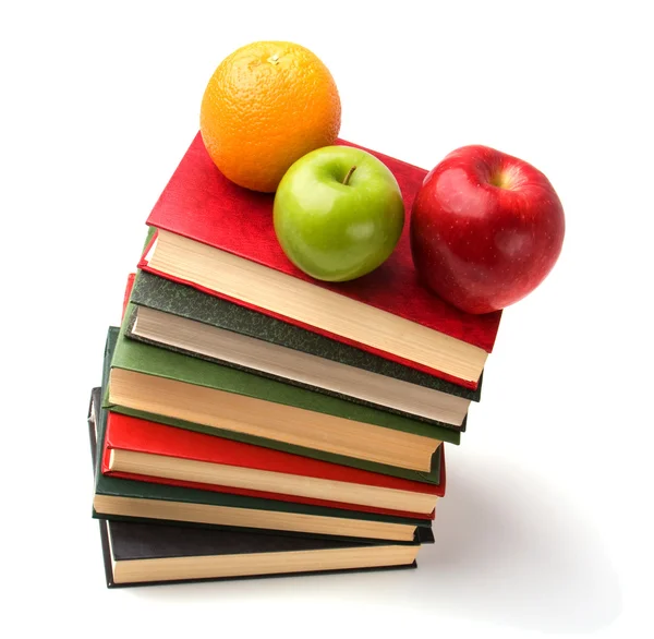Apilado de libros con frutas aisladas sobre fondo blanco — Foto de Stock