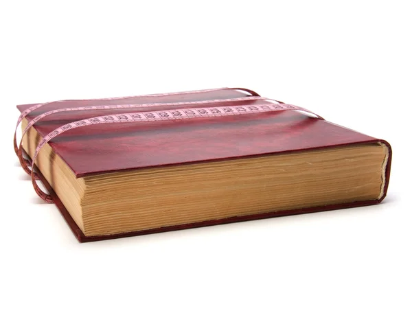 Meetlint gewikkeld rond boek geïsoleerd op witte achtergrond — Stockfoto