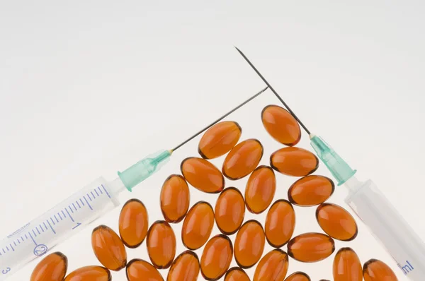 Medicamento cápsulas e seringas sobre branco — Fotografia de Stock