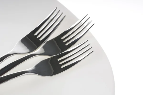 Forks on a plate over white — Stock Photo, Image
