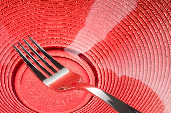 Tenedor en plato rojo —  Fotos de Stock