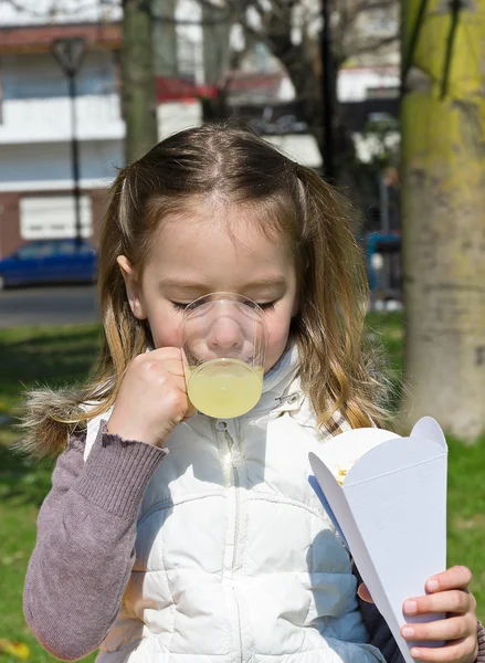 Kleines Mädchen trinkt einen Saft — Stockfoto