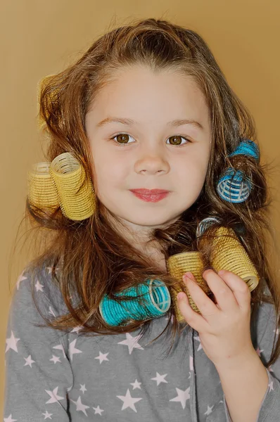 Girl smiles with curlers in hair — Stock Photo, Image